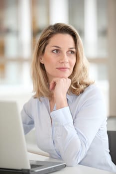 Smiling office worker in front of laptop computer