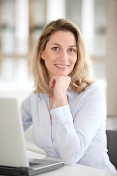 Smiling office worker in front of laptop computer