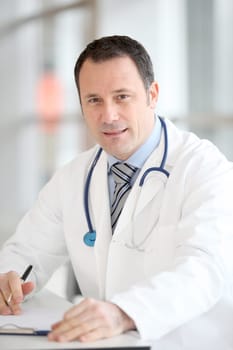 Closeup of handsome doctor sitting at his desk