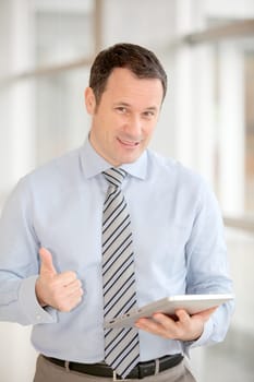 Businessman standing in hall with electronic tab