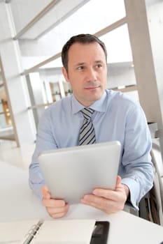 Businessman sitting in the office with electronic tab