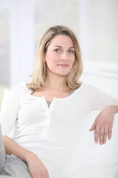 Portrait of beautiful blond woman sitting on sofa