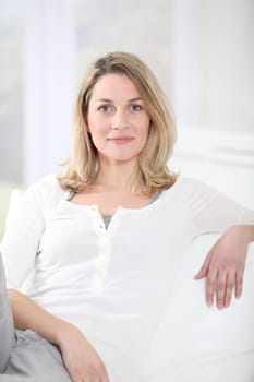 Portrait of beautiful blond woman sitting on sofa