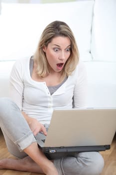 Surprised woman in front of laptop computer