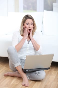 Surprised woman in front of laptop computer