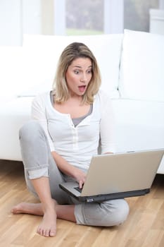 Surprised woman in front of laptop computer