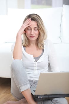 Blond woman using laptop computer at home