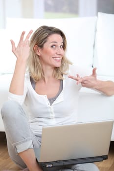 Happy woman using laptop computer at home