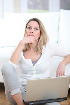 Woman with thoughtful look using laptop computer