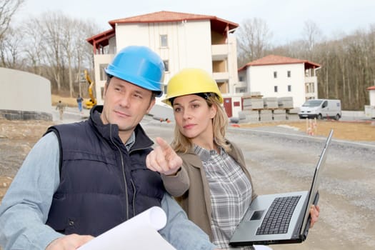 Architect and engineer looking at plan on construction site