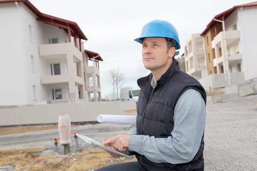 Supervisor using electronic tab on construction site