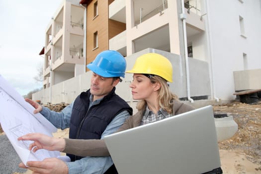 Architect and engineer looking at plan on construction site