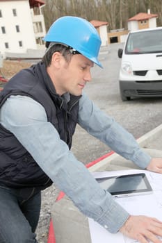 Engineer on construction site with electronic tab