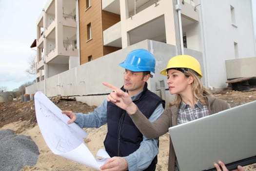 Architect and engineer looking at plan on construction site