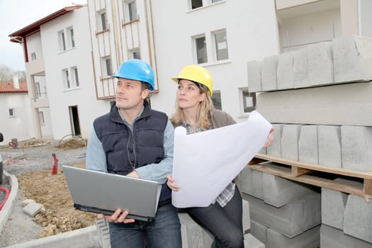 Architect and engineer looking at plan on construction site