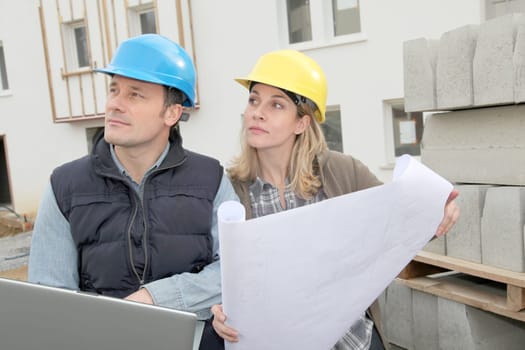 Architect and engineer looking at plan on construction site