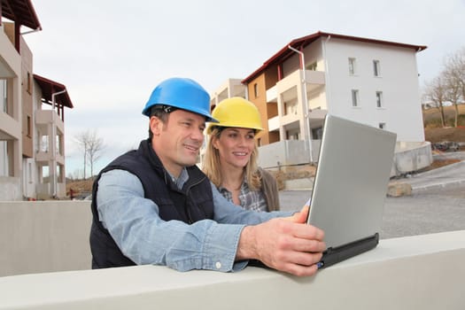 Architect and engineer looking at plan on construction site