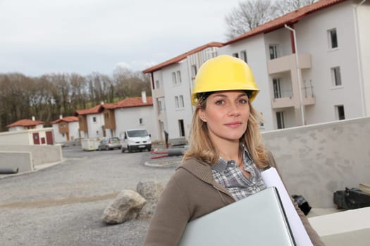 Woman engineer with security helmet standing on construction site