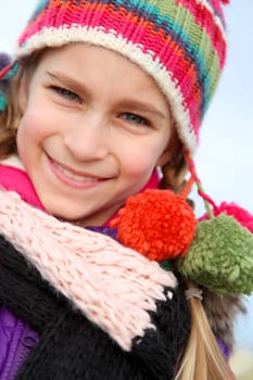 Portrait of blond little girl wearing wool cap