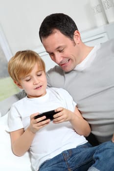 Father and son playing video game at home