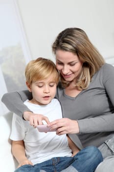Mother and son playing video game on telephone