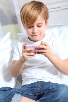 Portrait of little blond kid playing video game