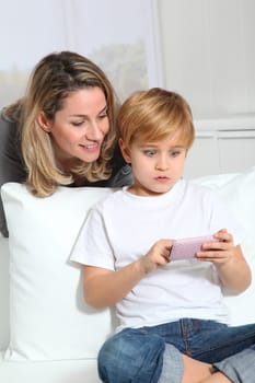 Mother and son playing video game on telephone