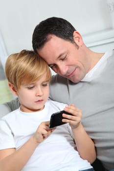 Father and son playing video game at home