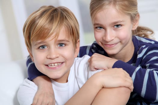 Portrait of young children sitting in sofa at home