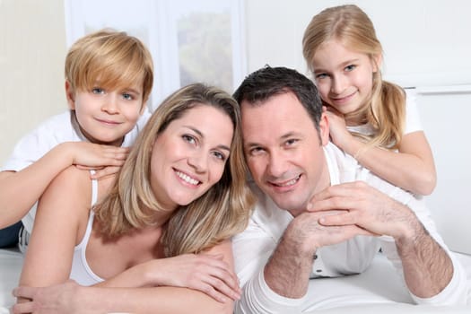Happy family laying on bed