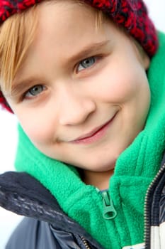 Portrait of blond little boy wearing wool cap