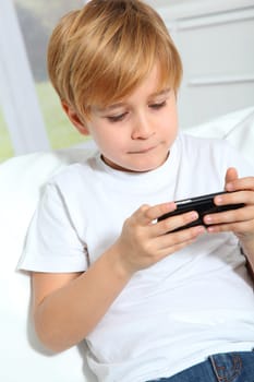 Portrait of little blond kid playing video game