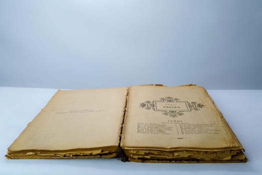 Open old book with fragile, yellowed pages and a vintage black-and-white illustration. Aged historical literature, perfect for themes of knowledge, history, and nostalgia