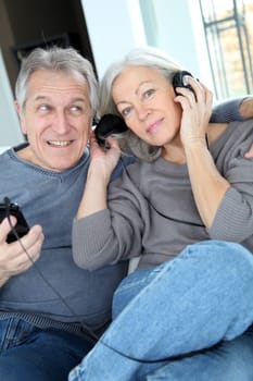 Senior couple listening to music with headphones