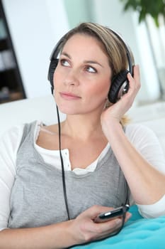 Blond woman listening to music with headphones