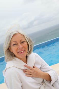 Senior woman sitting by pool