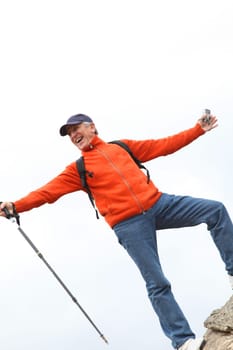 Senior trekker standing on rock