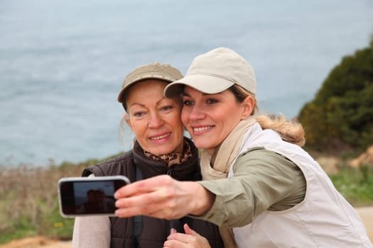 Women taking picture of themselves with telephone