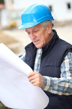 Architect with drawing on construction site