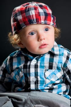 Casual cool young kid with cap against gray background
