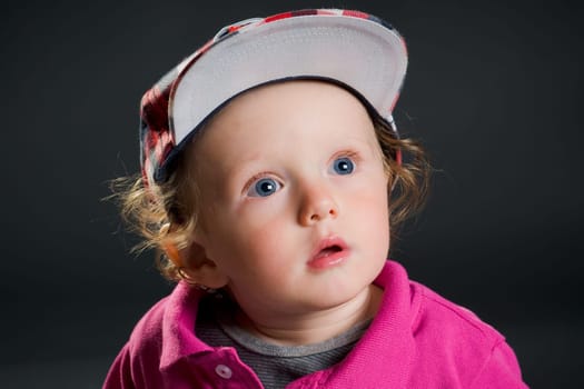 Casual cool young kid with cap against gray background
