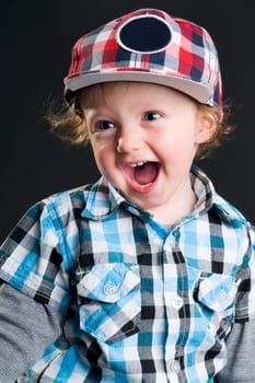 Casual cool young kid with cap against gray background