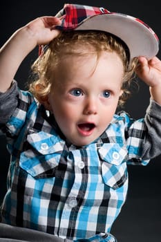 Casual cool young kid with cap against gray background