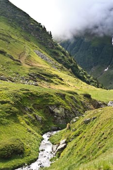 a small river flowing over a mountain valley