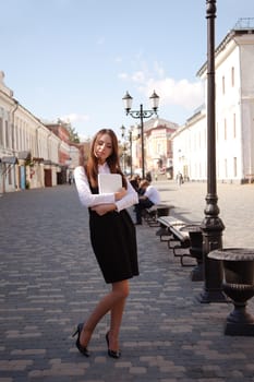 Young beauty student with notebook in old town