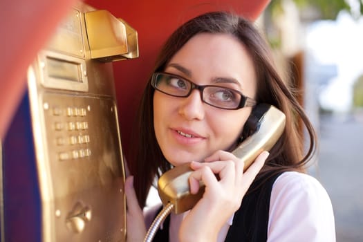Young happy girl call from gold street phone
