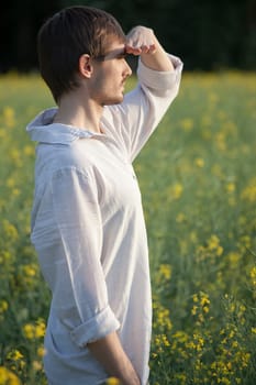 man in field looking into the sun