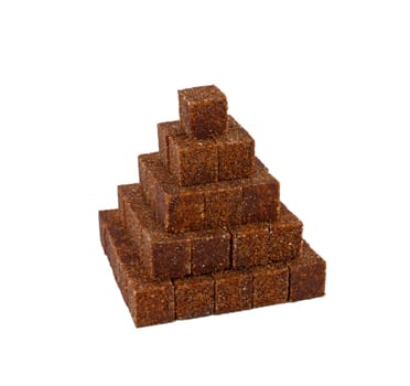 Pyramid made of cane sugar cubes isolated on white