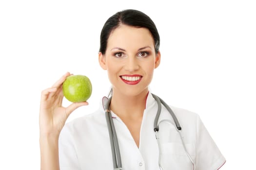 Healthy eating or lifestyle concept. Smiling woman doctor with a green apple.