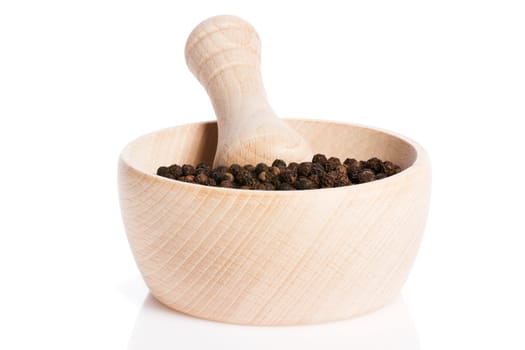 Peppercorns in a wooden mortar against a white background